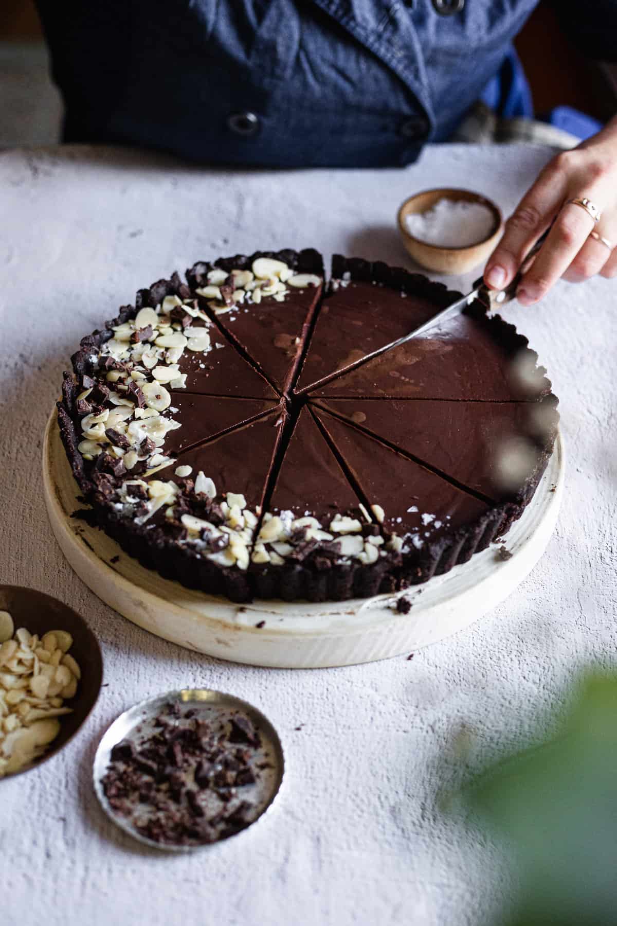 cutting a slice from chocolate tart
