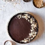 A paleo chocolate tart topped with almonds.