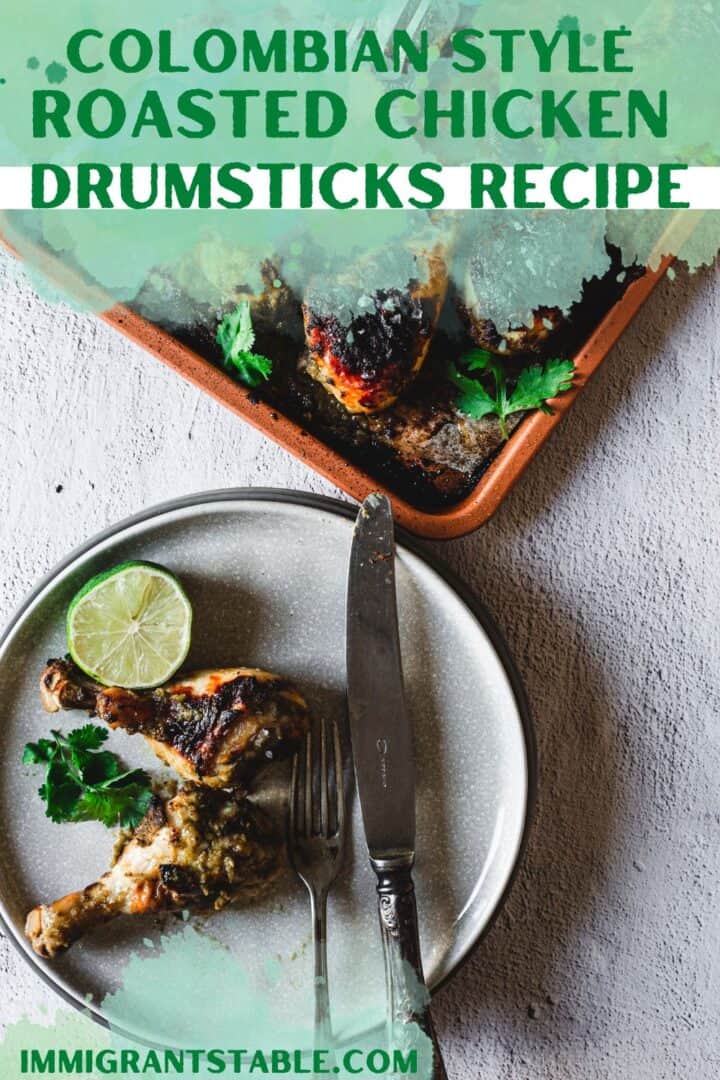 two roasted chicken legs with lime on a plate, fork and knife and tray of chicken drumsticks