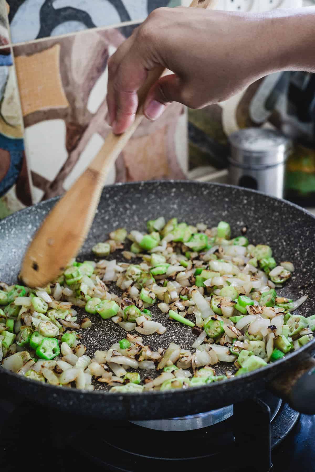 Frying okra and onions in pan