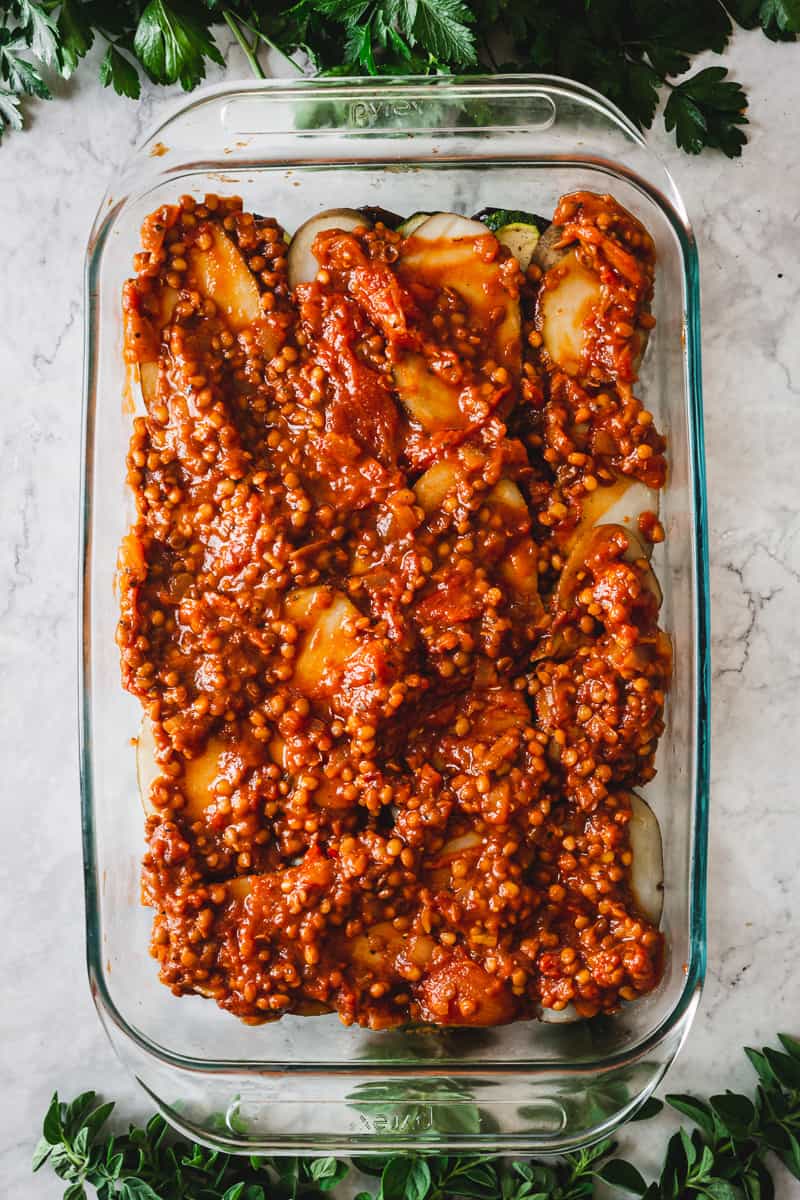 layer of lentils in tomato sauce in a casserole dish