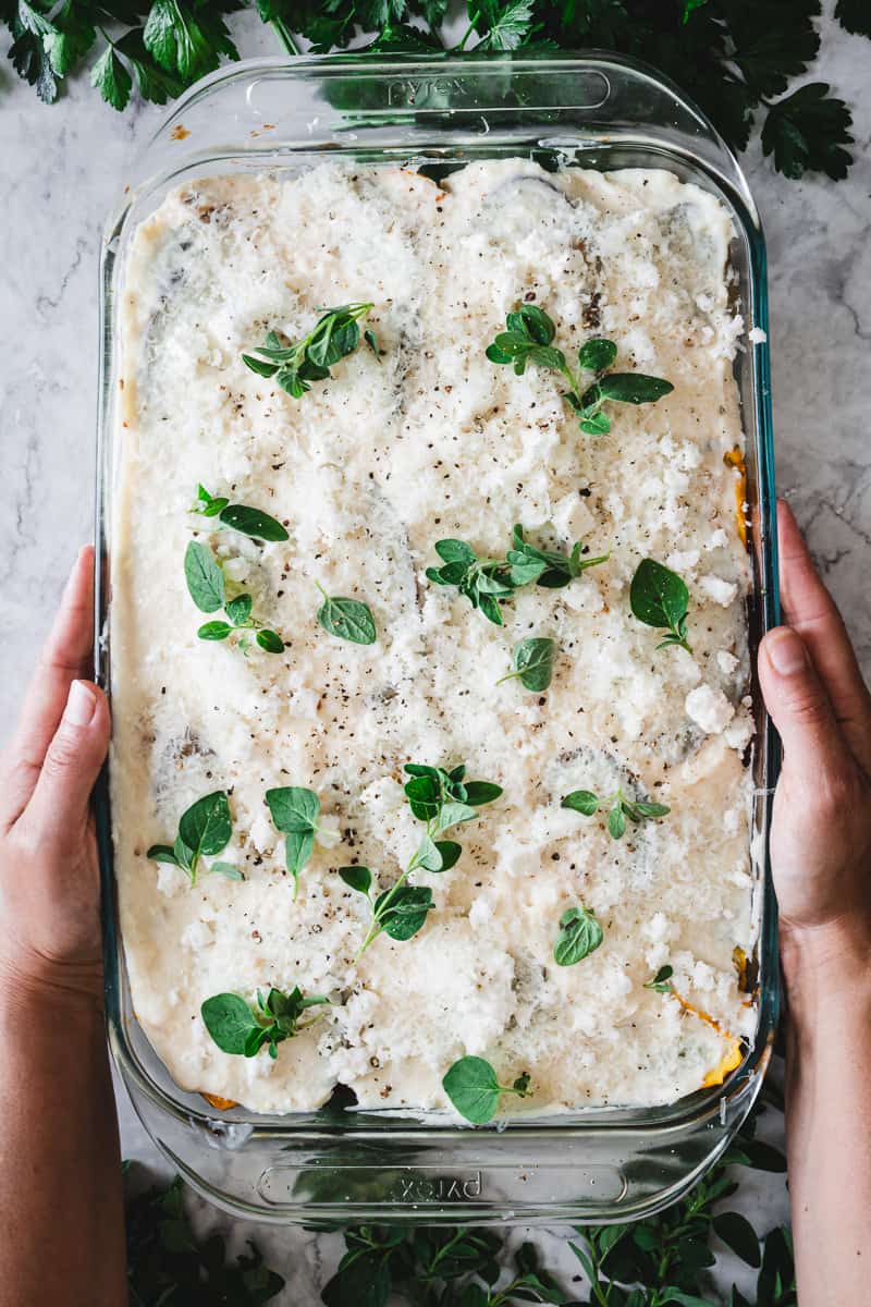 vegetarian moussaka topped with fresh oregano going to the oven