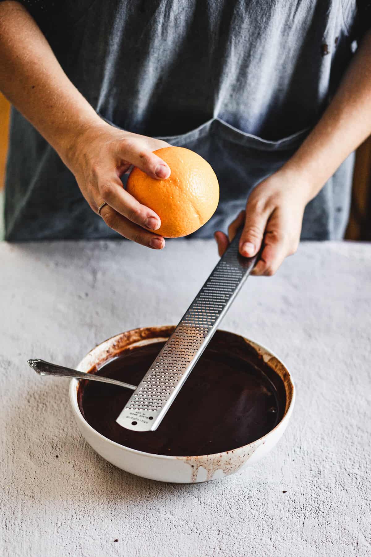 grating orange zest into chocolate ganache