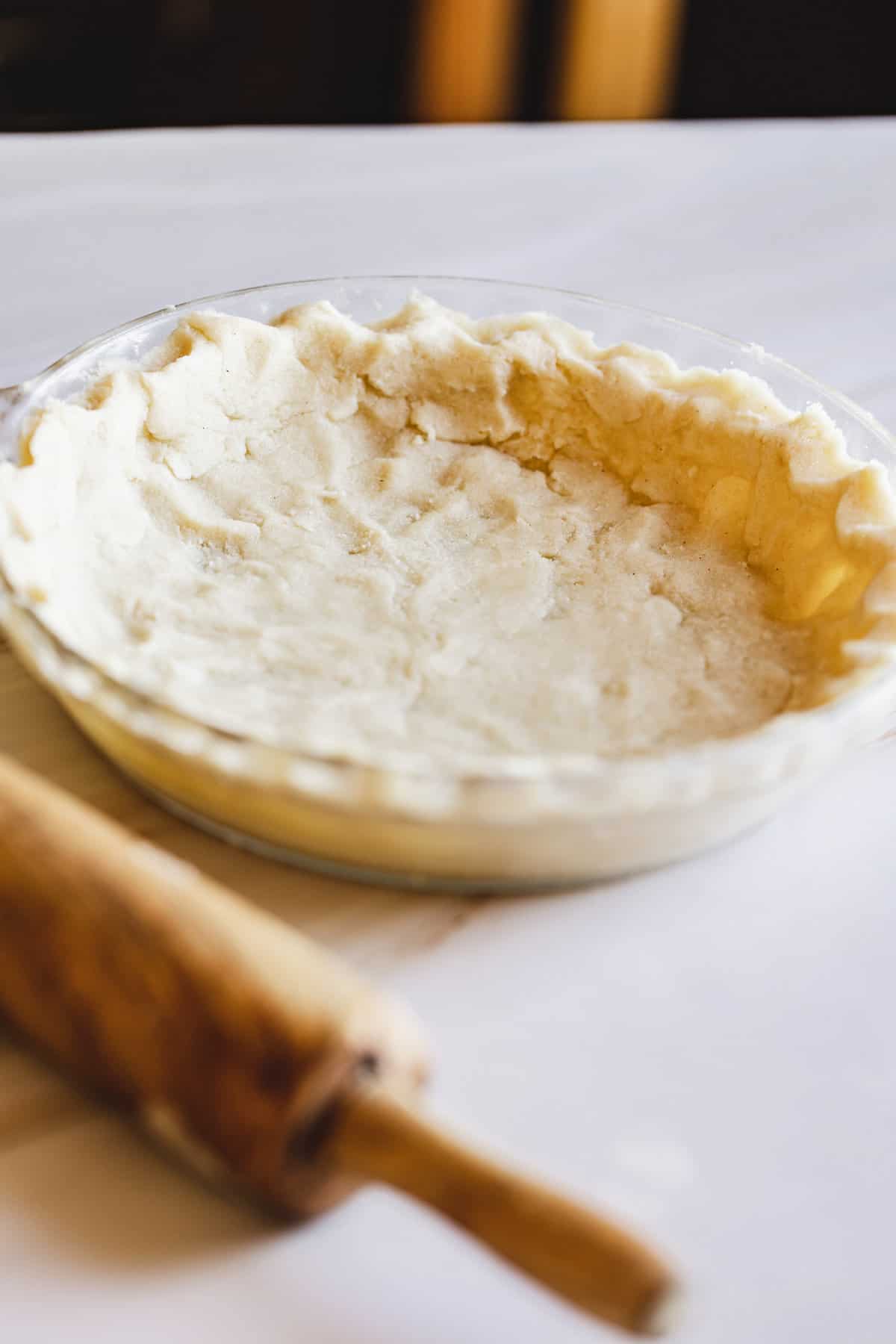 gluten free pie crust in pie plate with rolling pin
