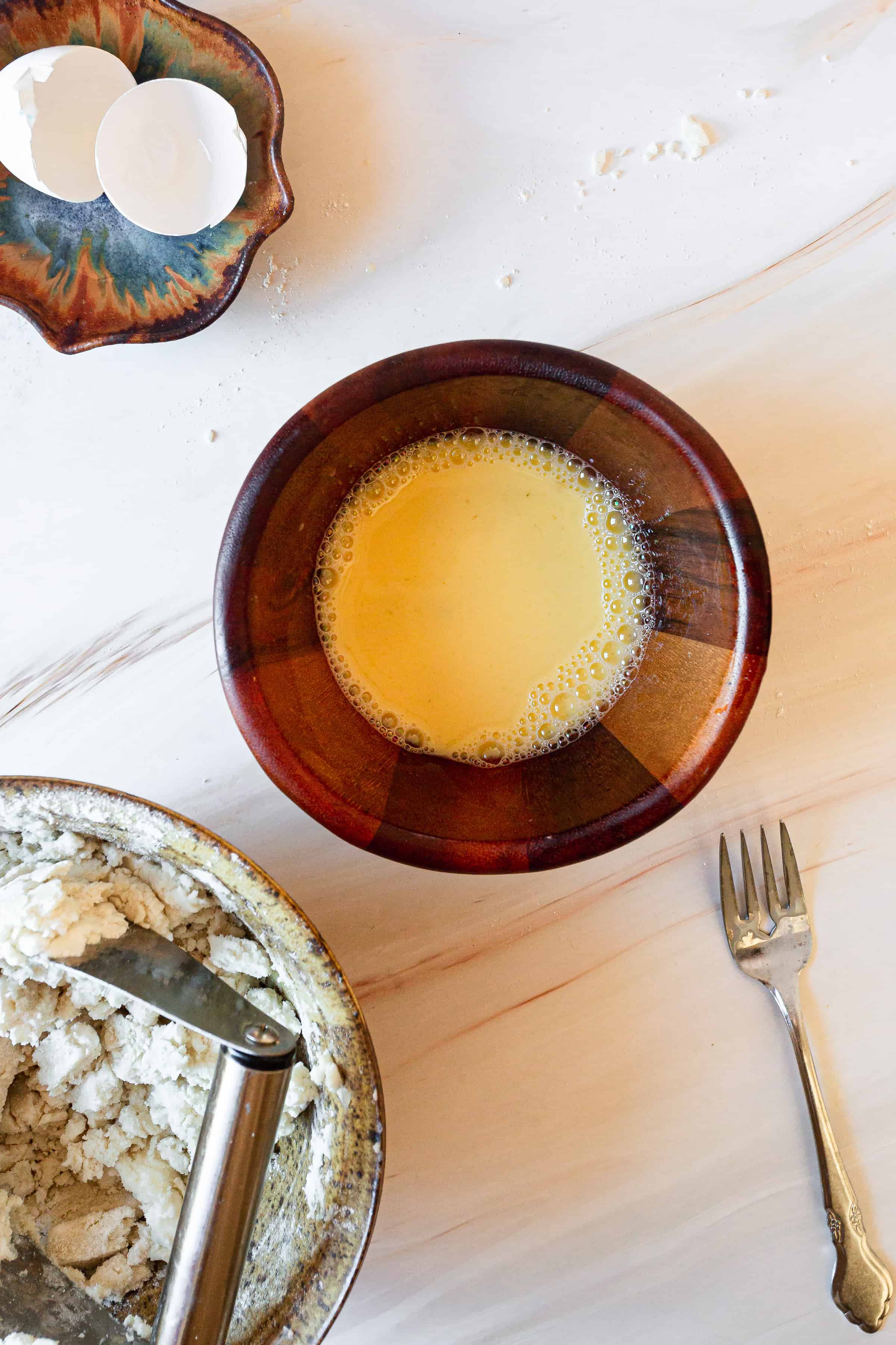 egg, vinegar and water in bowl with fork