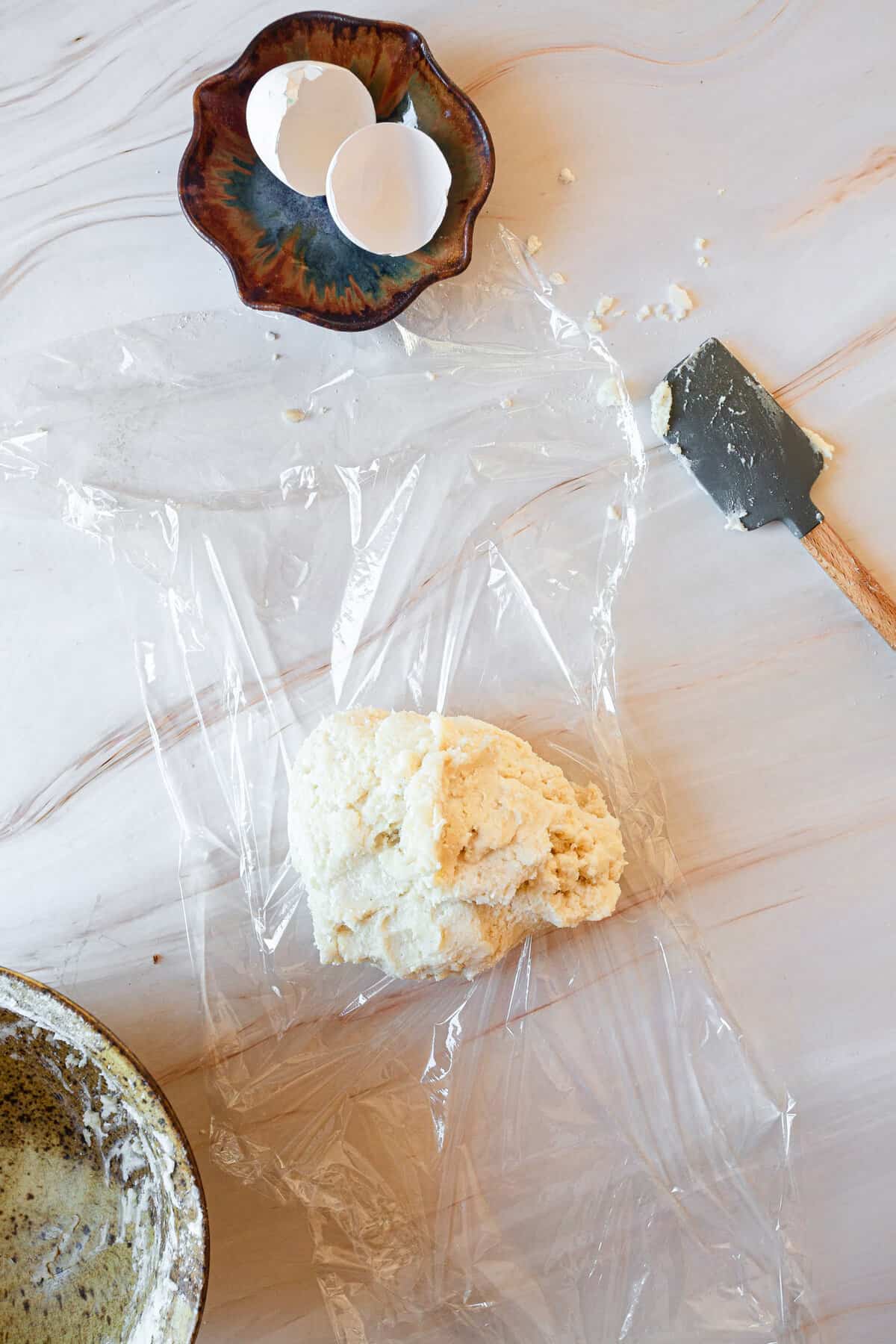 covering dough with plastic wrap