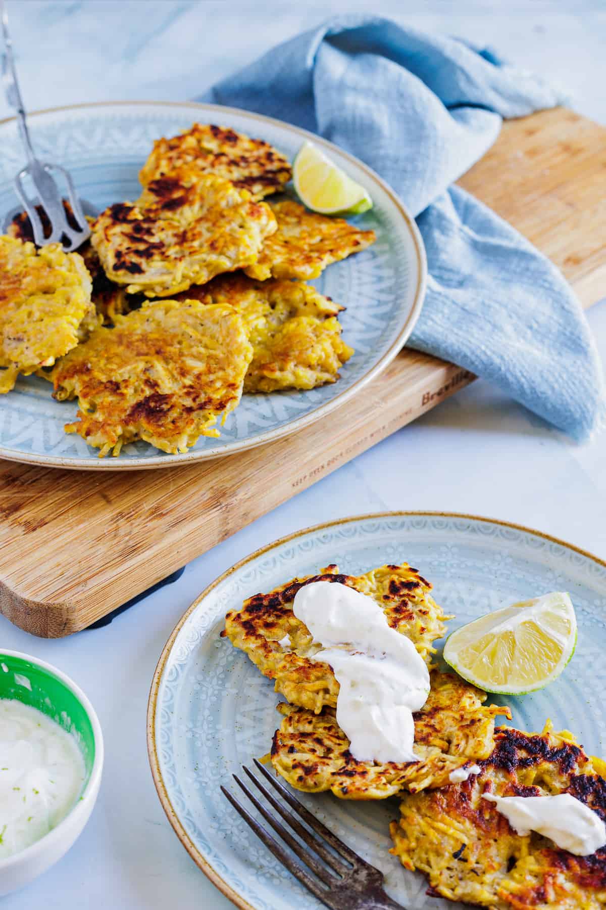 plantain latkes on big blue plate and small serving with fork
