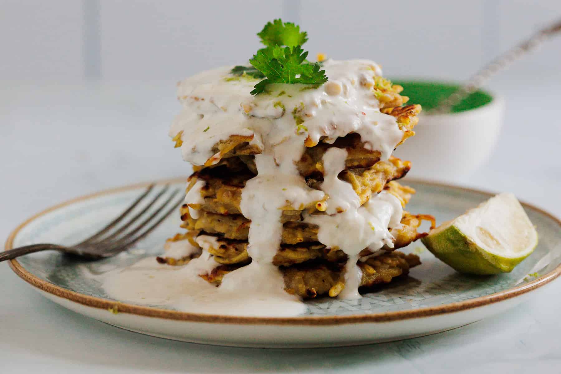 stack of latkes with lime cream and cilantro leaf