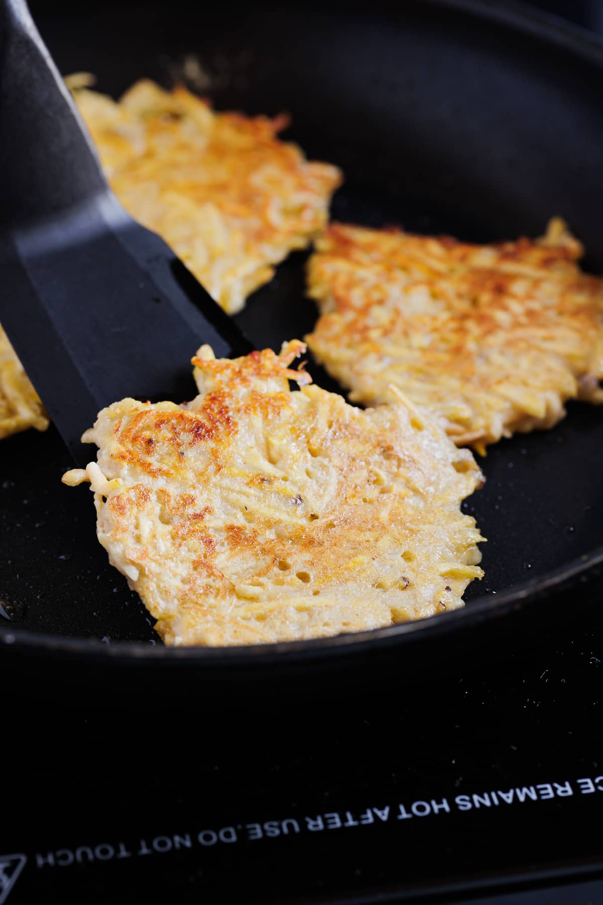 flipping latkes in pan