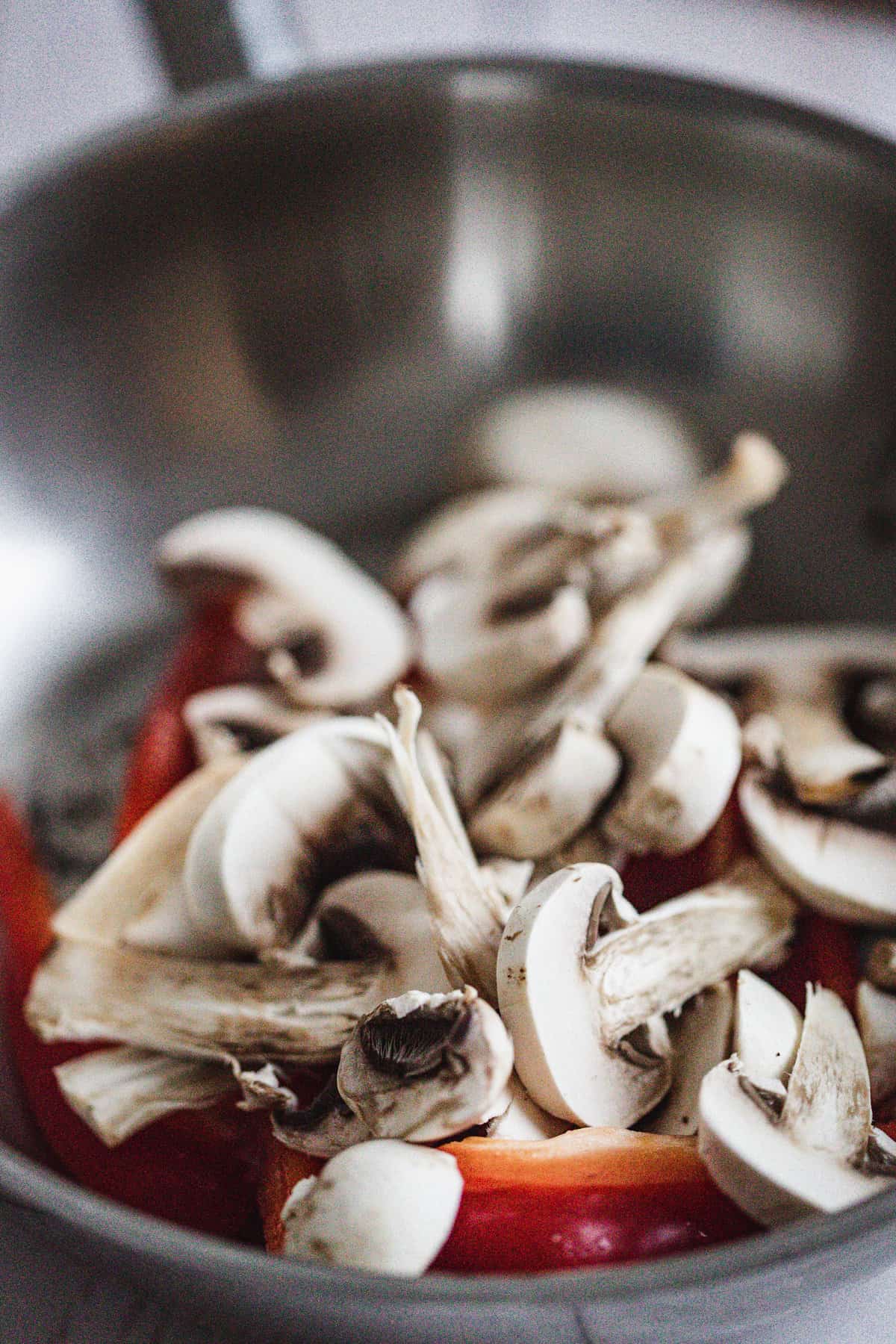 mushrooms and bell peppers in a frying pan