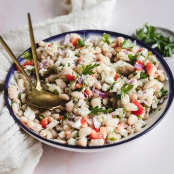 white bean salad in platter with spoons