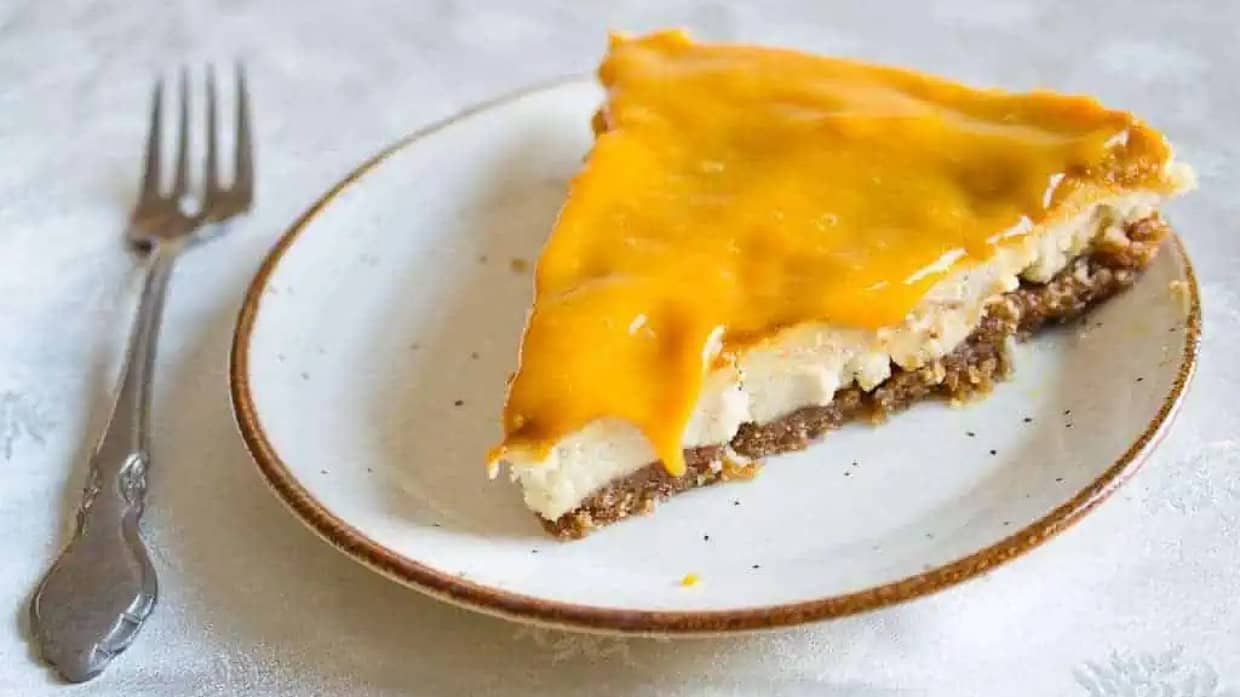 vegan mango cheesecake on plate with fork