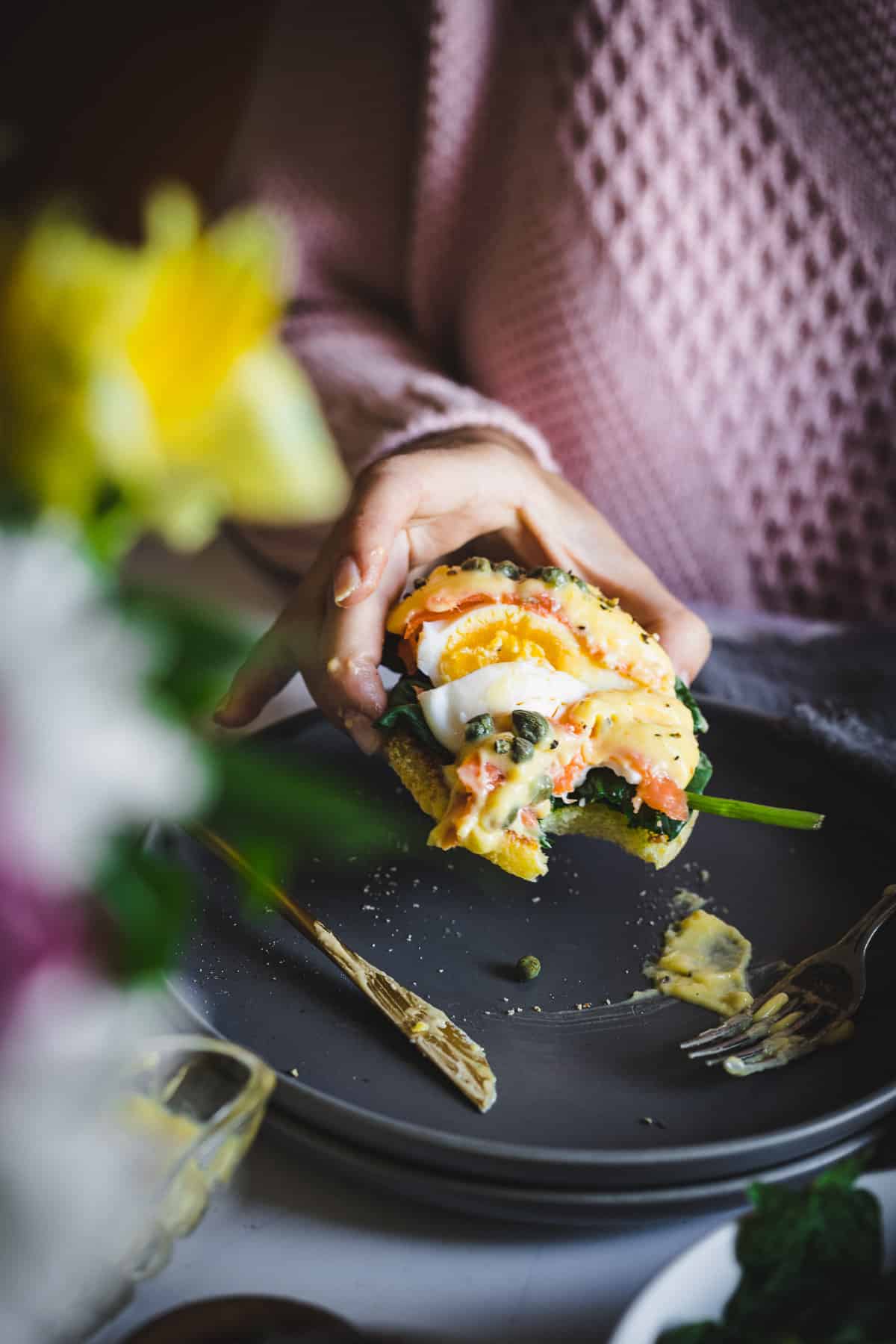 lifting cut eggs benedict portion with bite taken out