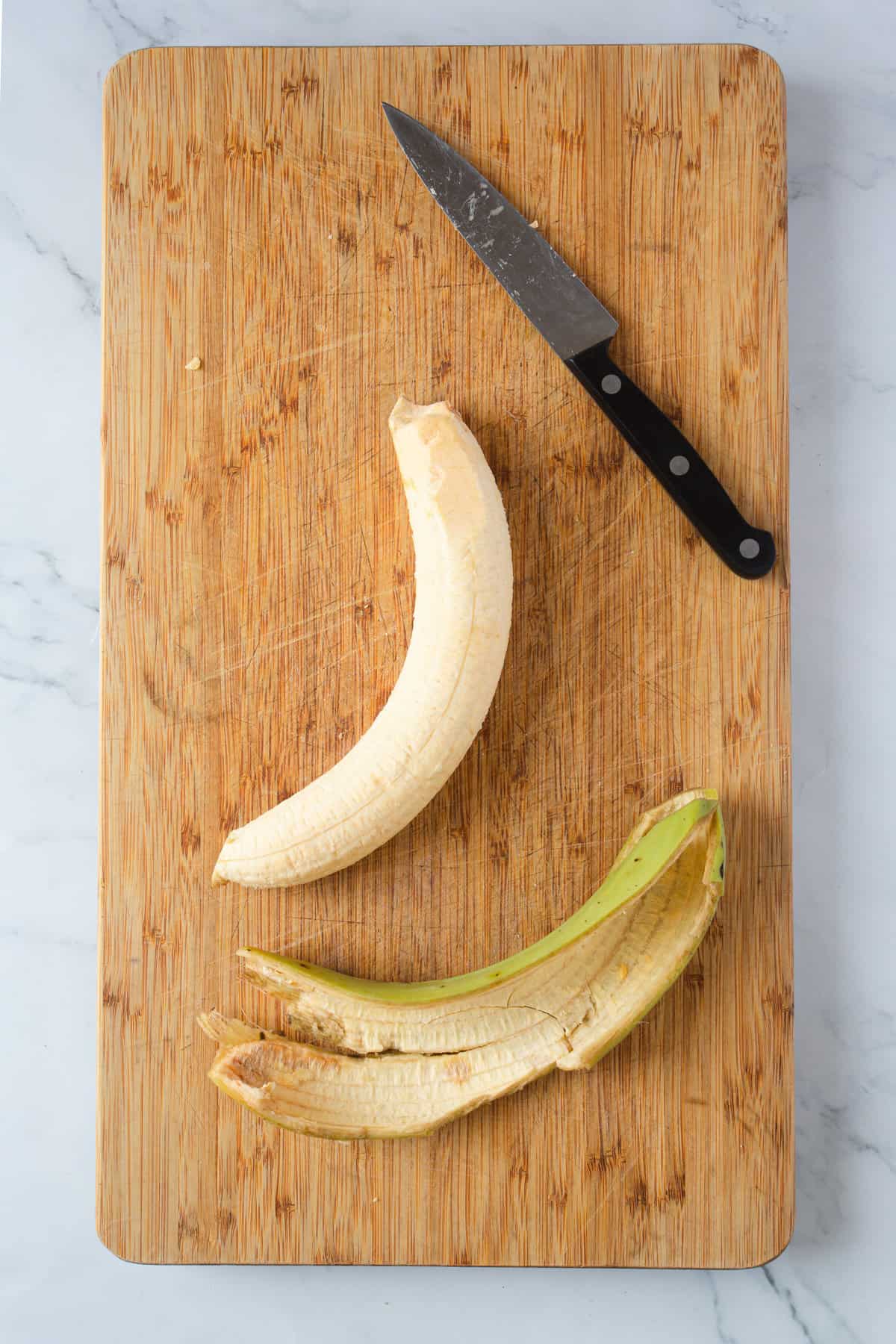 peeling a plantain on wooden board