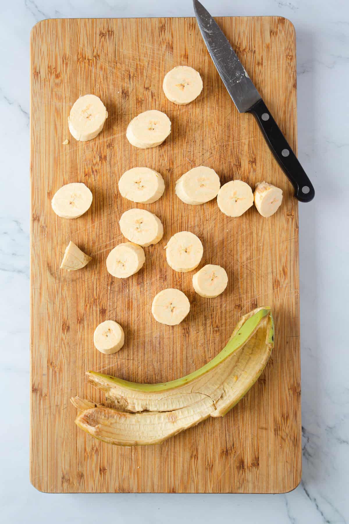 slicing a plantain on wooden board