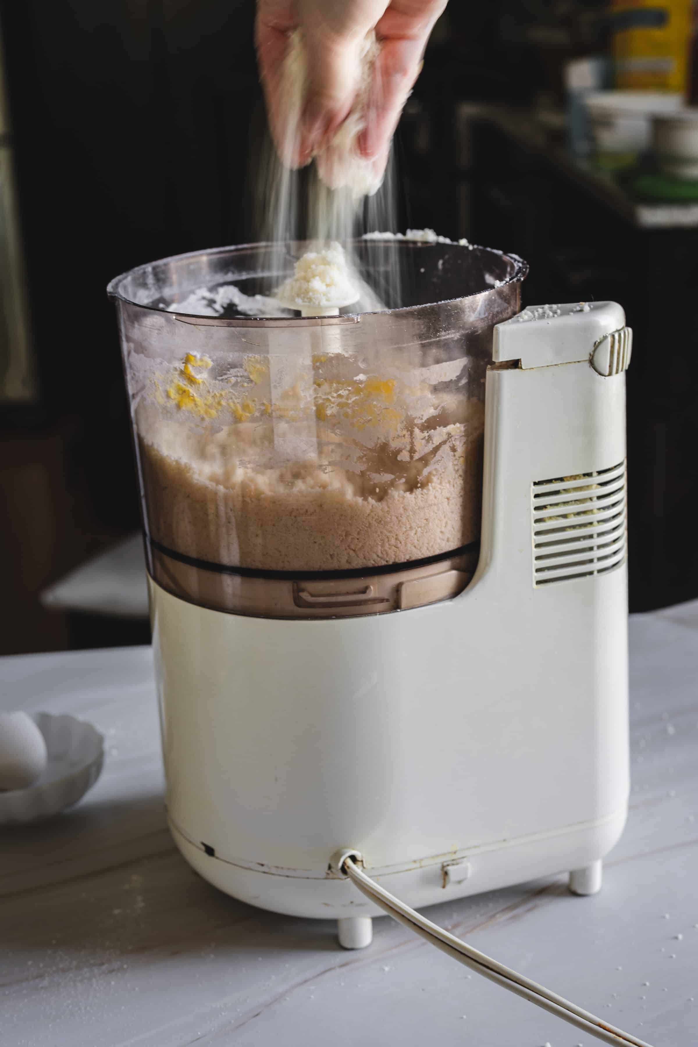 food processor full of ground ingredients for the crust