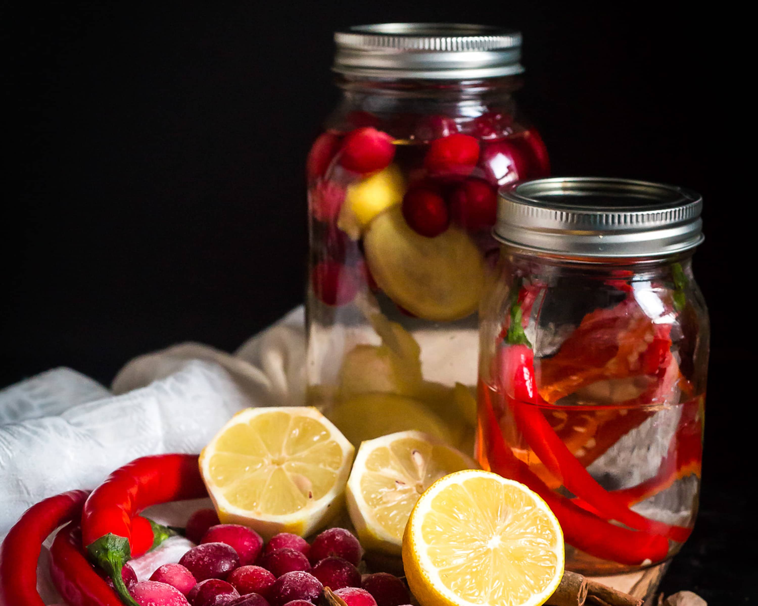 Two different vodka infusion jars with ingredients