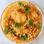 Overhead view of a freshly garnished dish of sweet potato hummus.