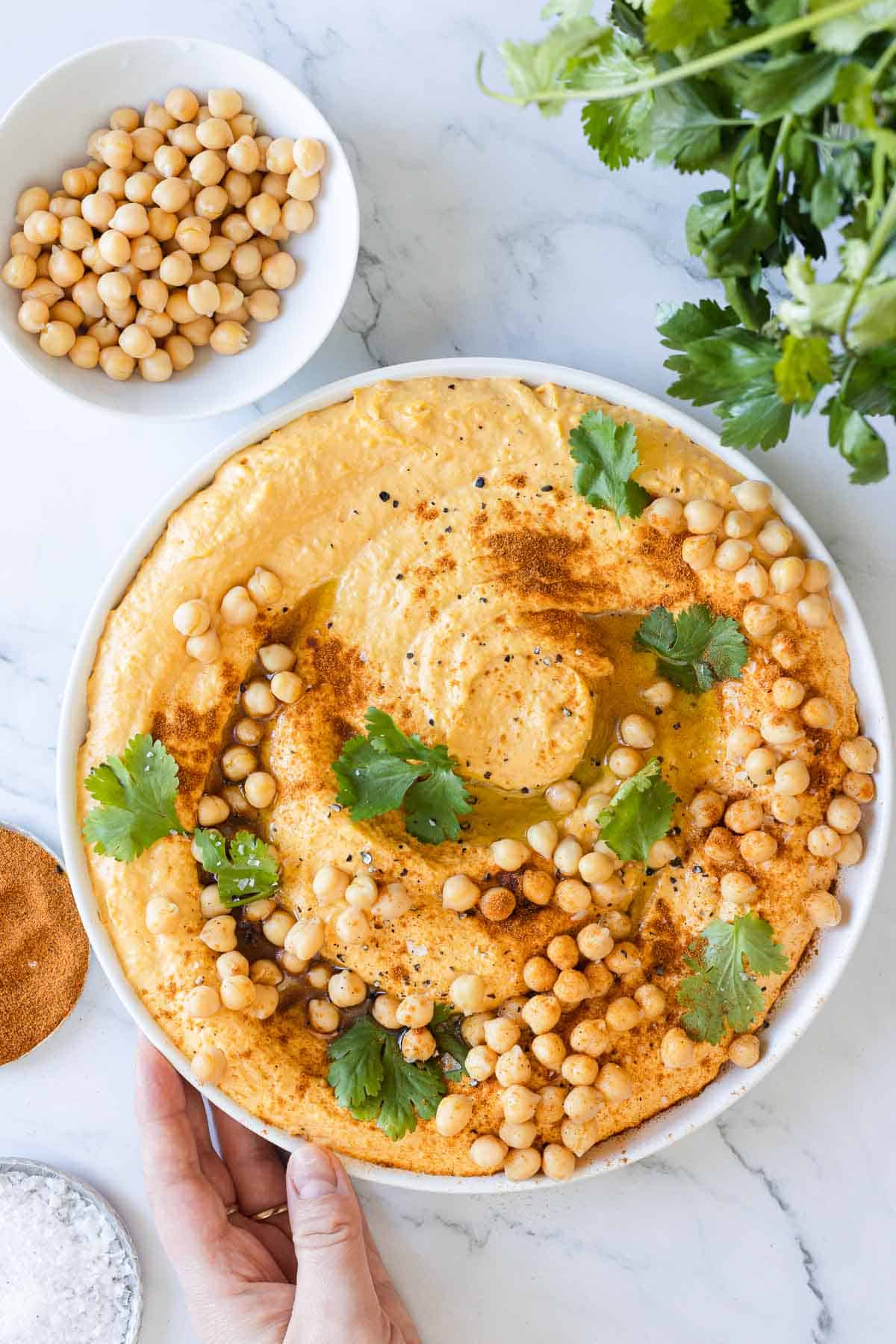 Overhead view of a freshly garnished dish of sweet potato hummus.