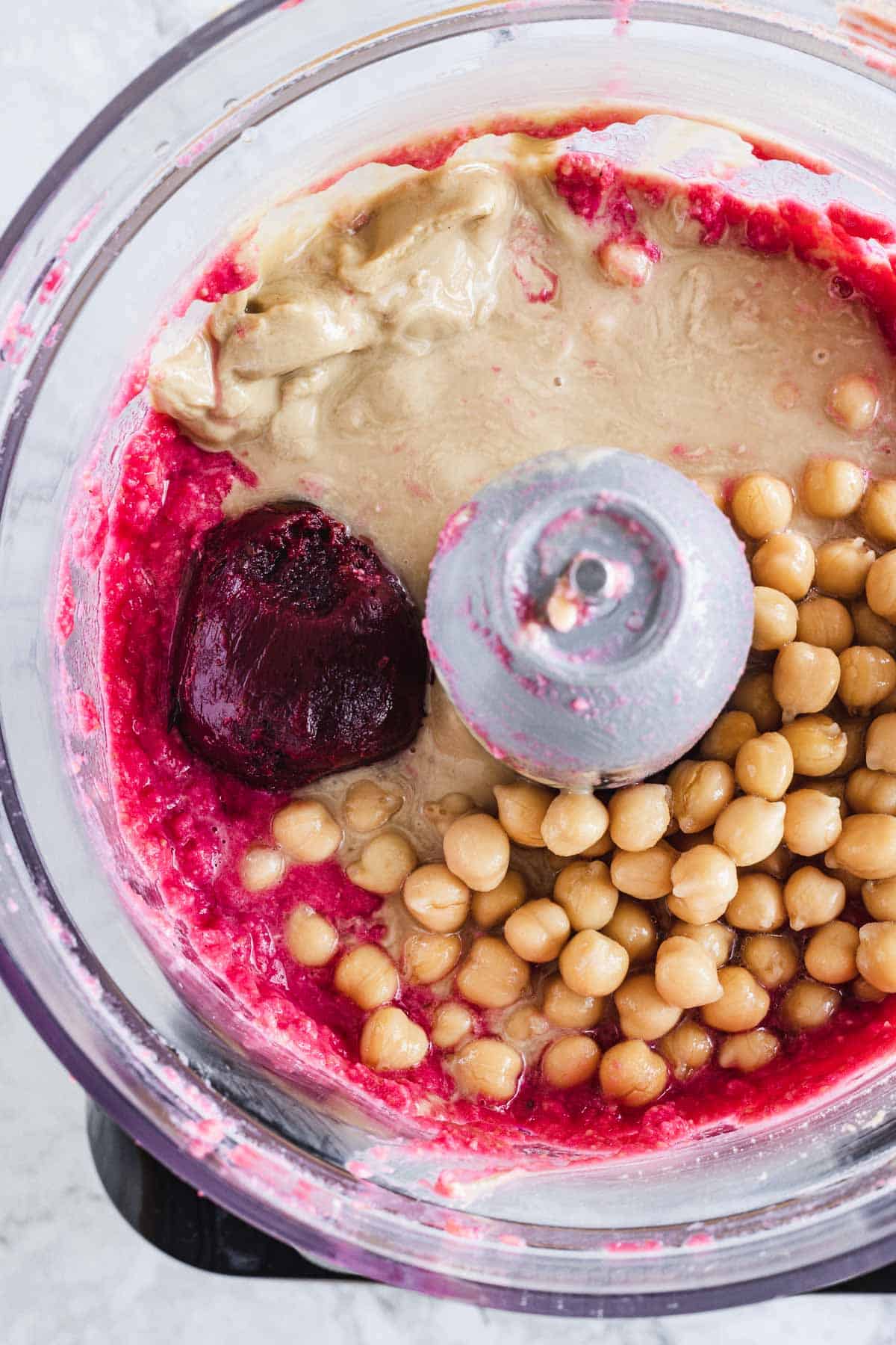 Beet hummus ingredients in a food processor.