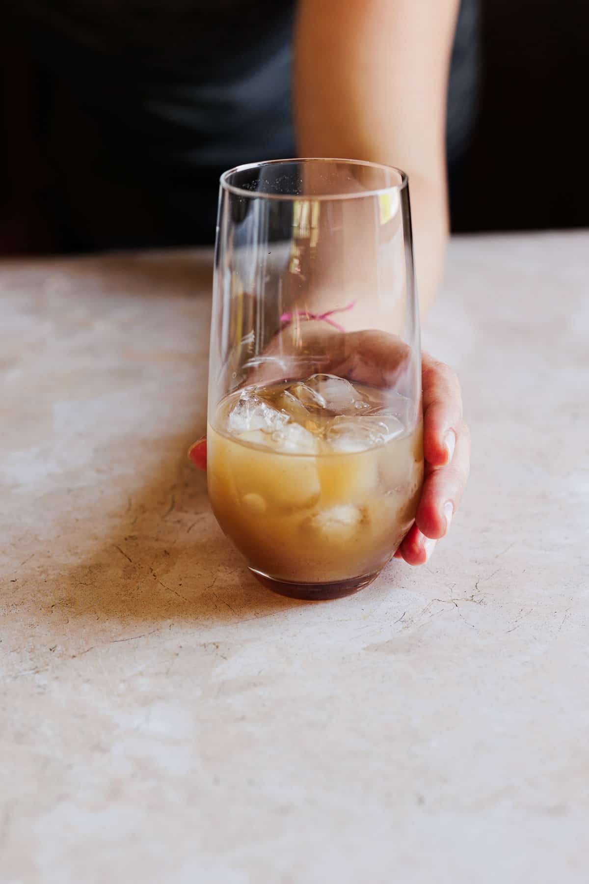 Ingredients being added to an ice filled glass.