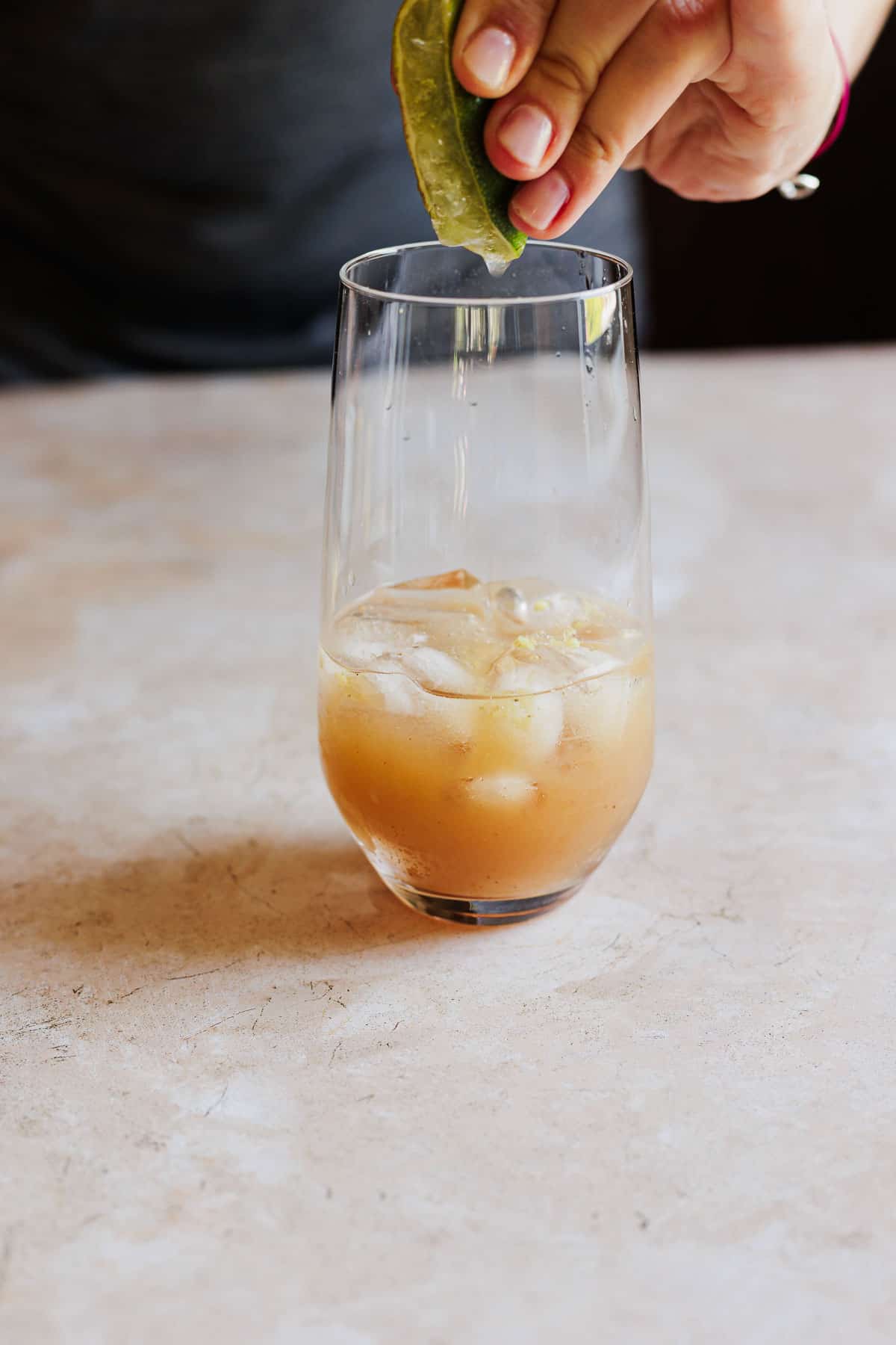 Ingredients being added to an ice filled glass.