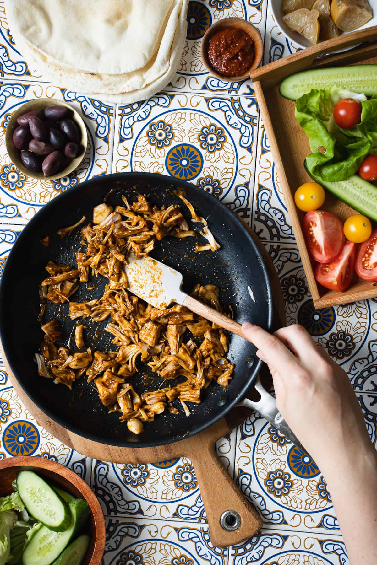 Mixing pulled jackfruit in pan with spatula.