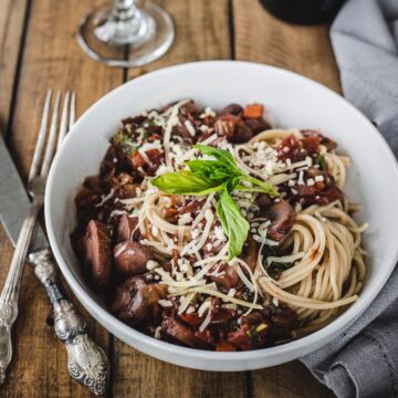 mushroom marinara sauce over spaghetti noodles with a glass of wine.