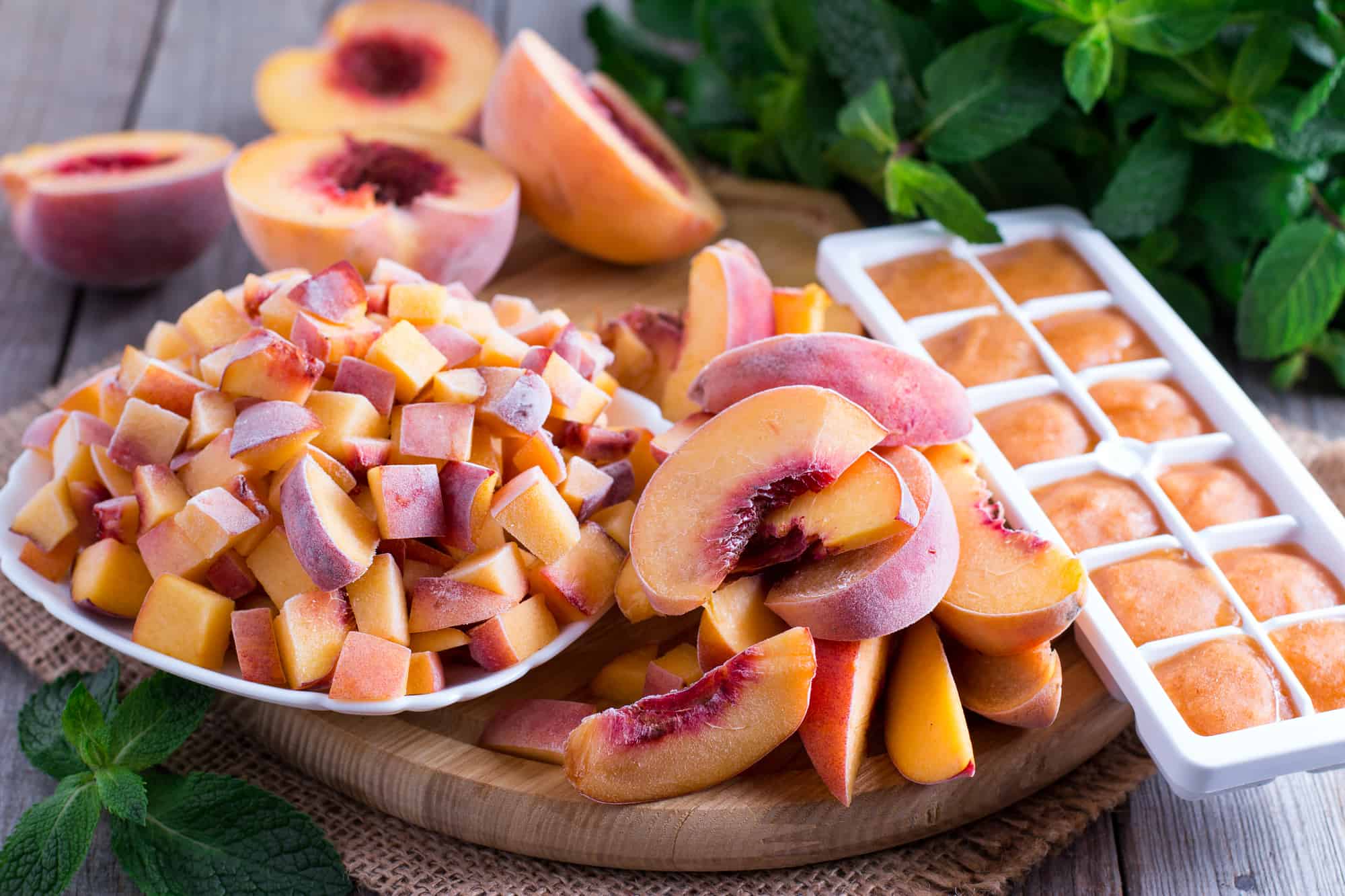 Learn how to freeze fresh peaches by making peach ice cubes on a wooden cutting board.