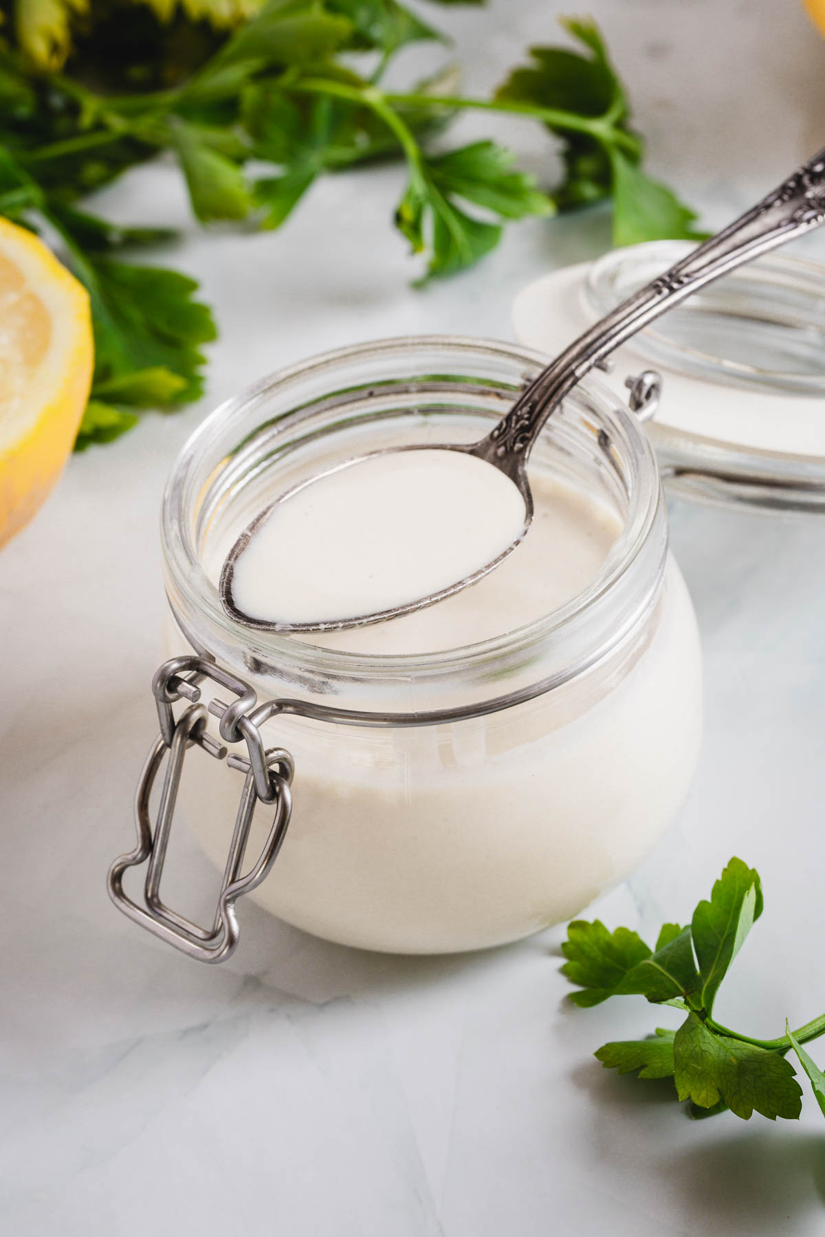 A jar of yogurt with lemons and parsley.