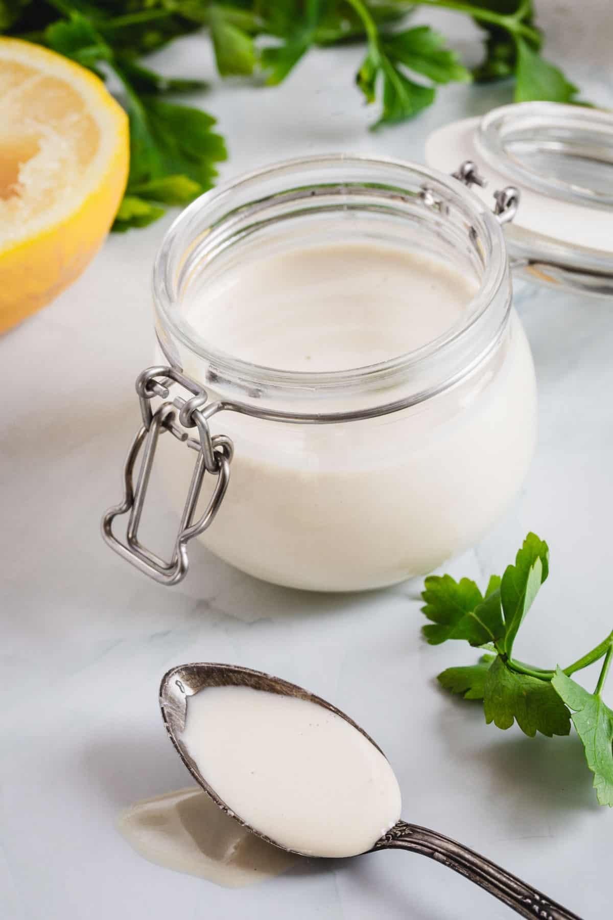 A jar of yogurt with lemons and parsley.