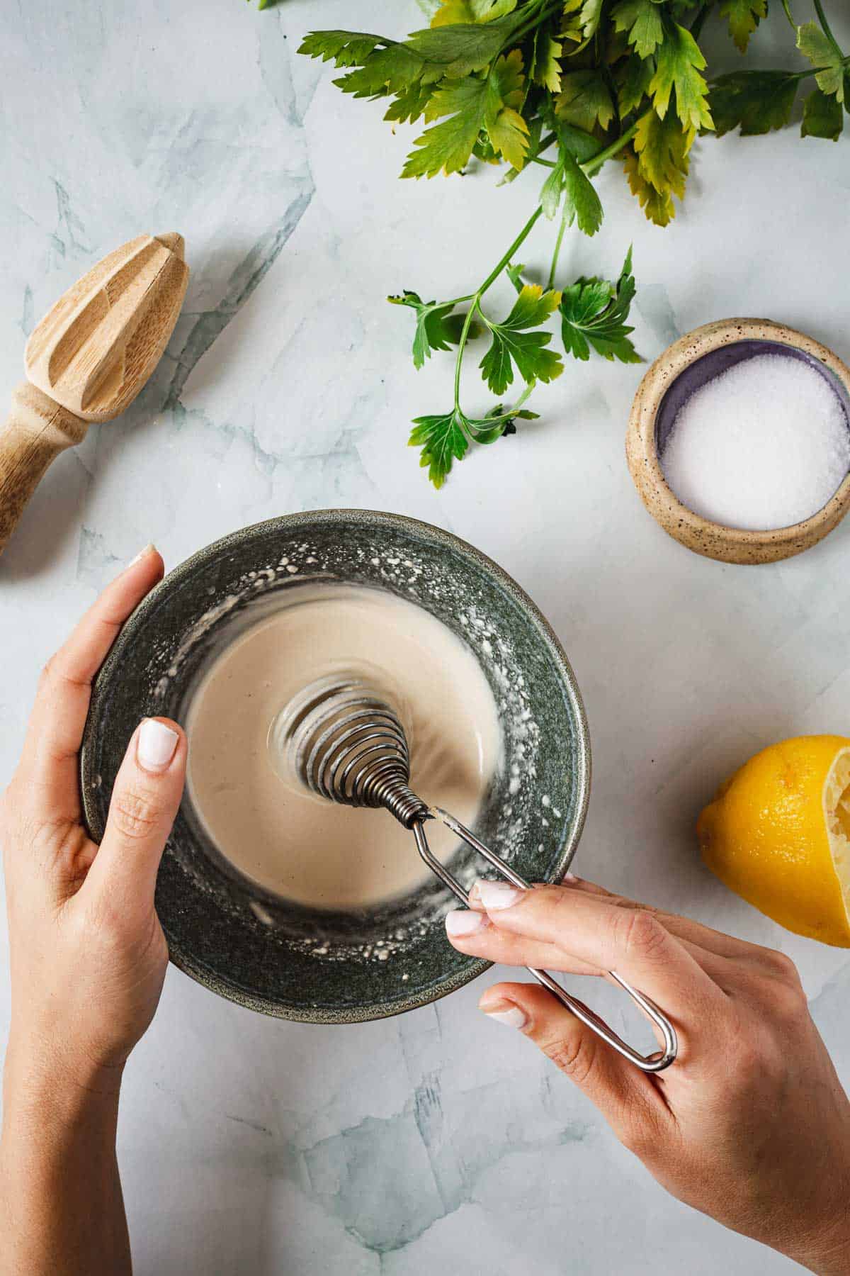 A woman is mixing lemon juice in a bowl with a spoon.