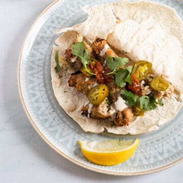 A white plate with a turkey kofta sandwich on it.