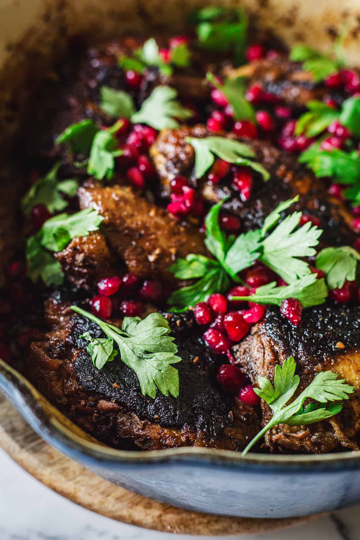 A skillet filled with meat and pomegranate.