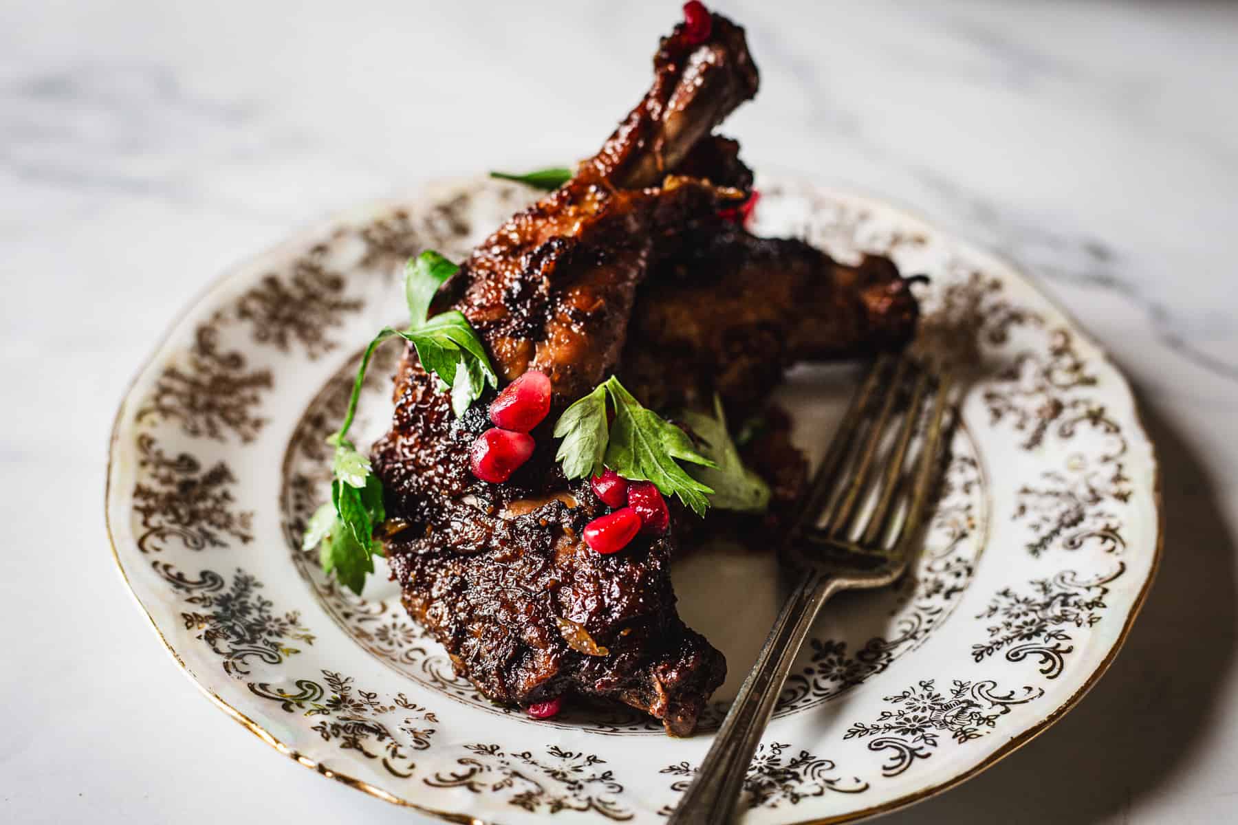 Roasted chicken with pomegranate on a plate.