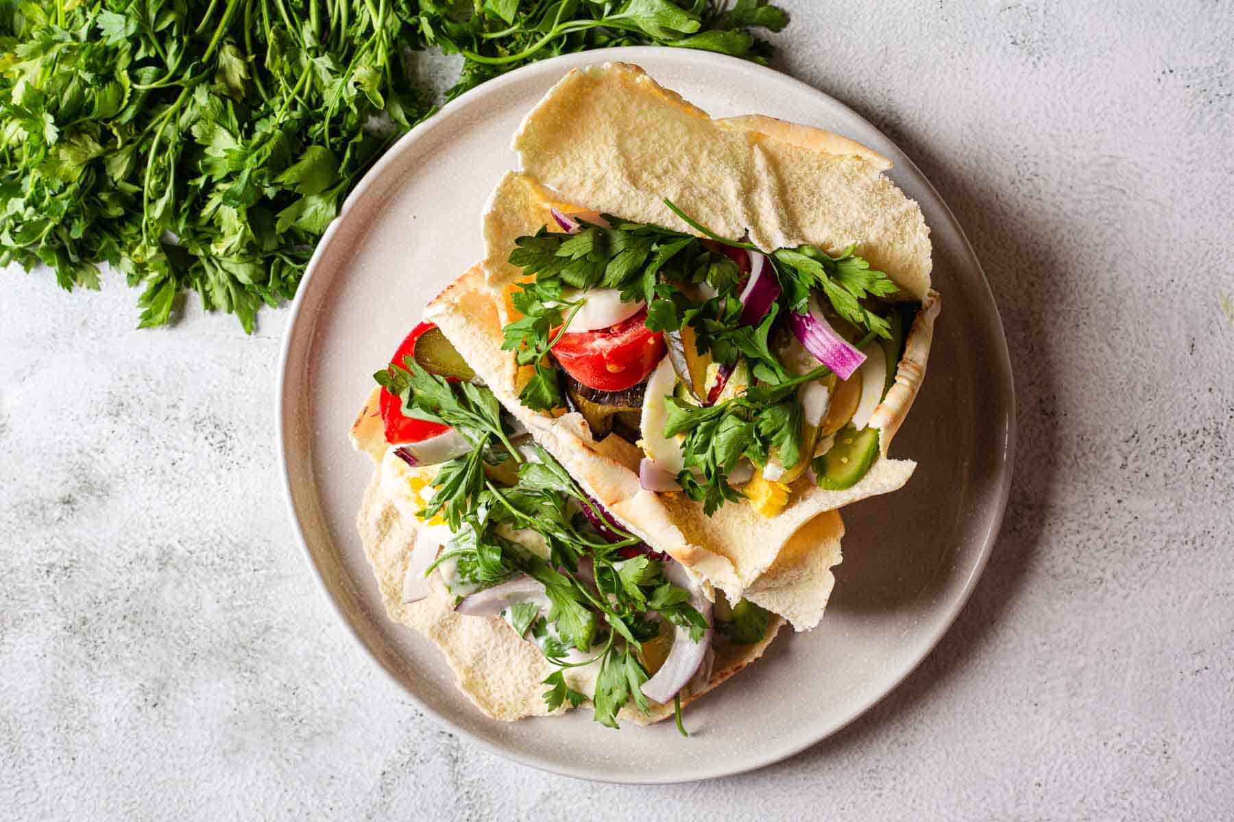 A plate with two pitas and vegetables on it.