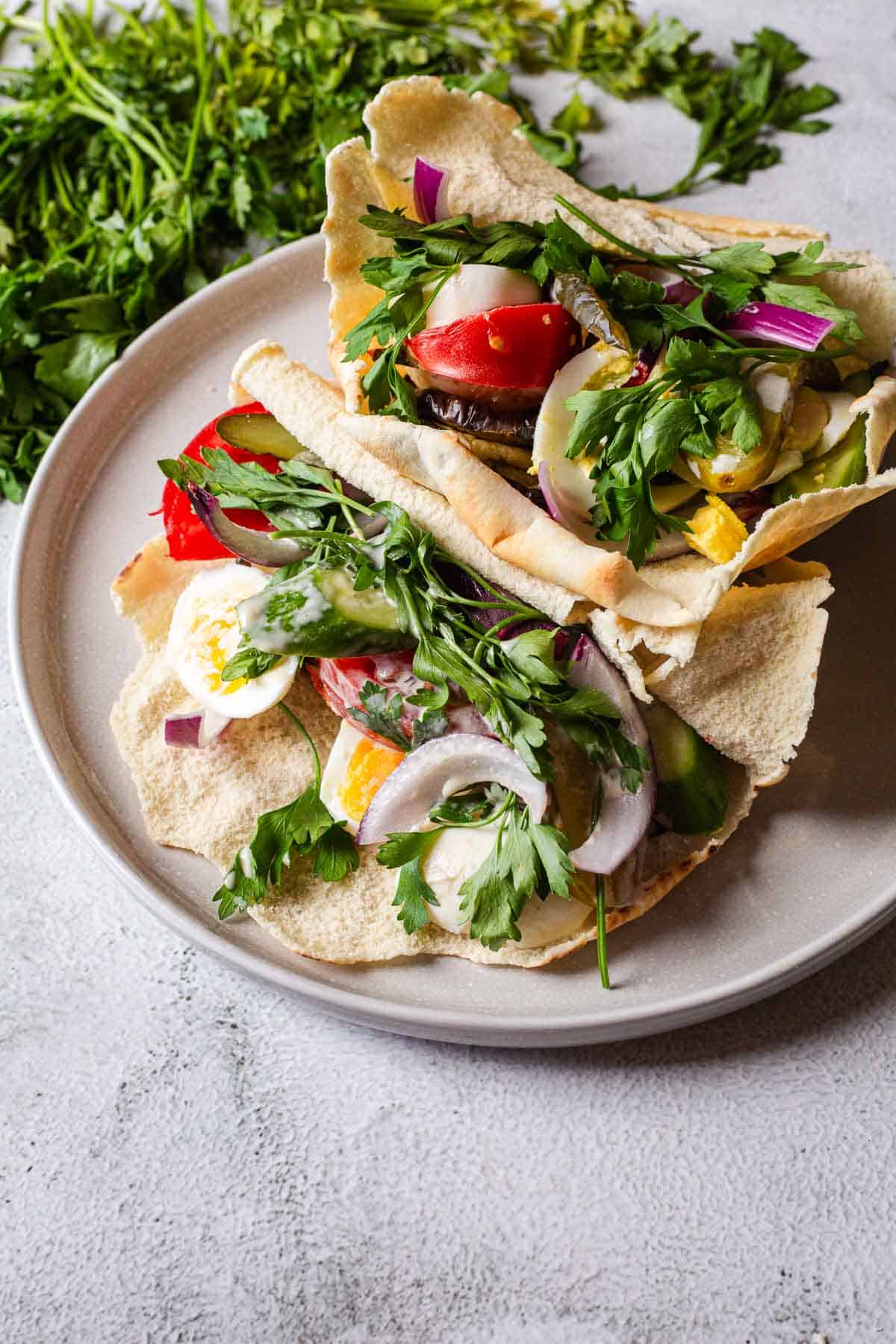 A plate with two pitas and vegetables on it.