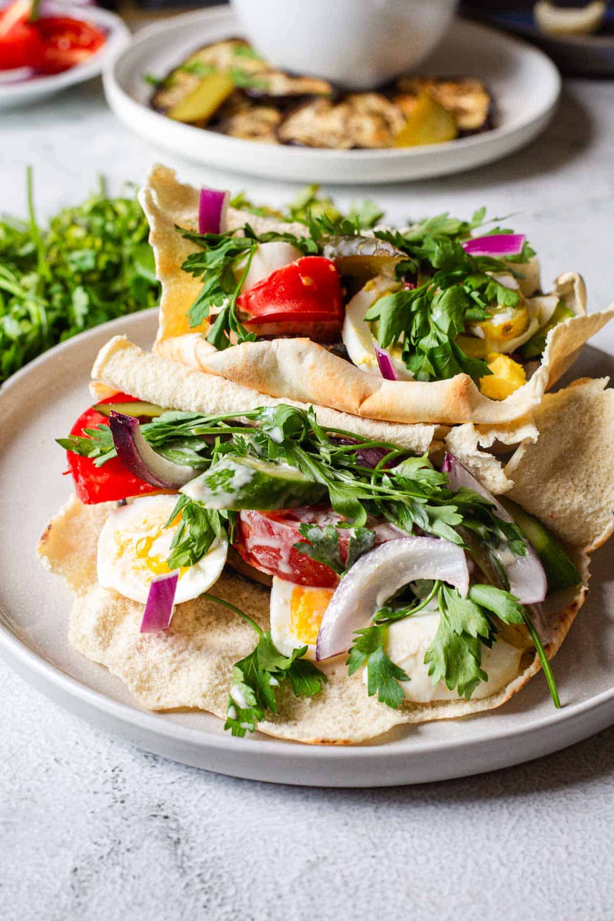A plate of pita bread with vegetables and eggs on it.