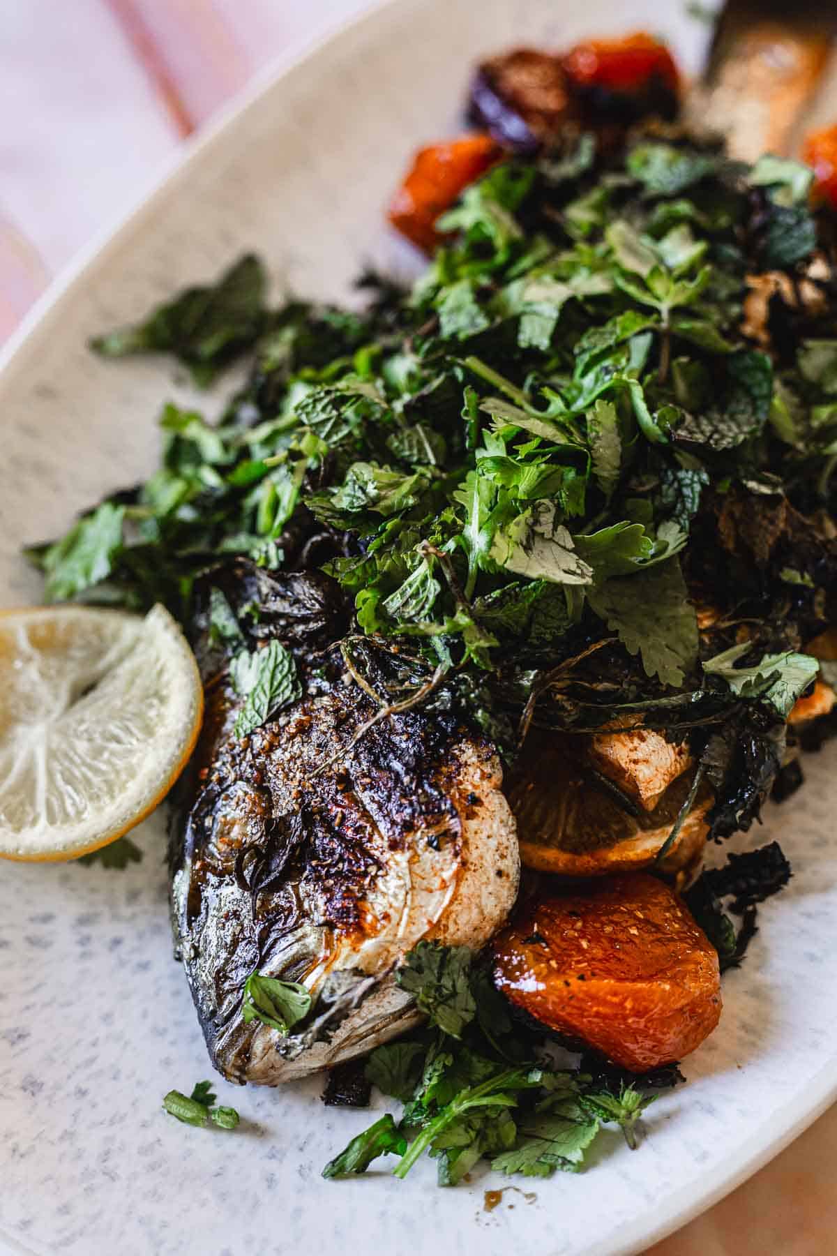 Plated whole fish on a white platter.