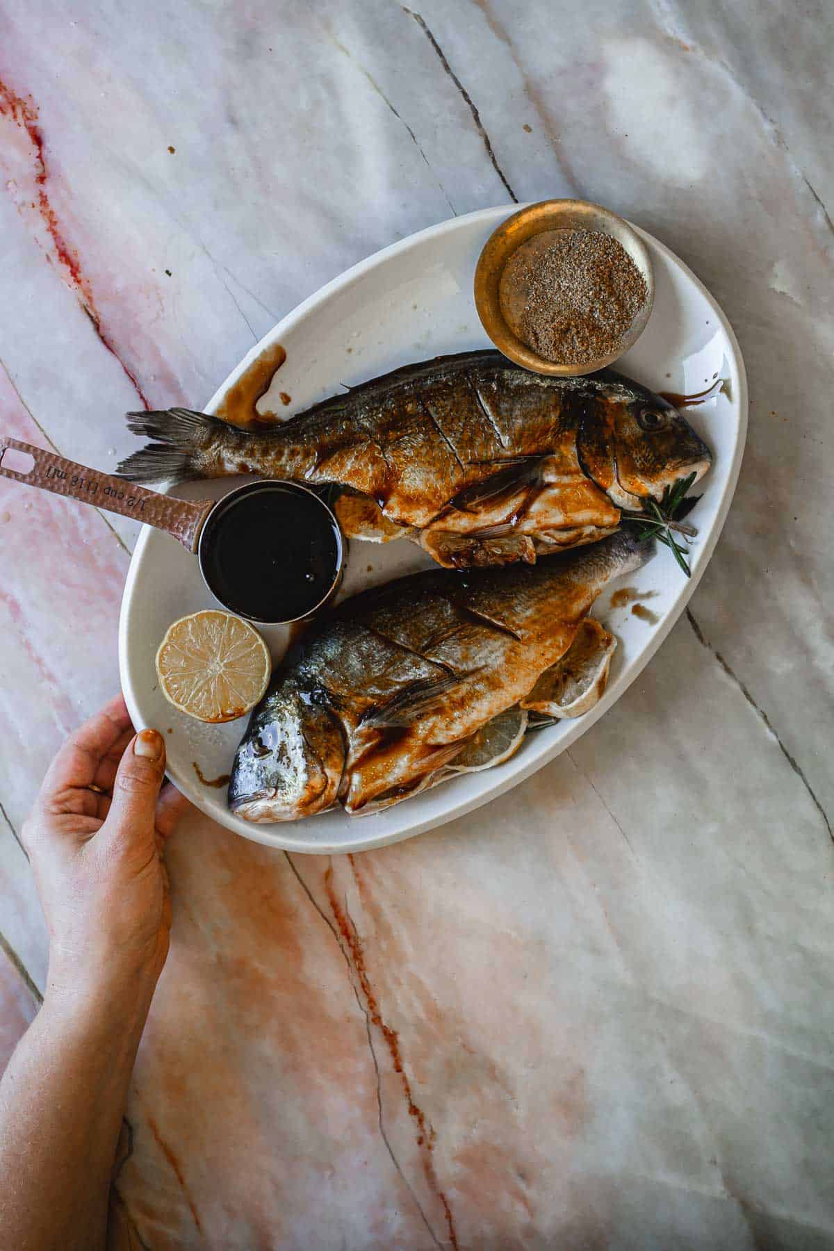 Raw whole fish covered in pomegranate sauce.