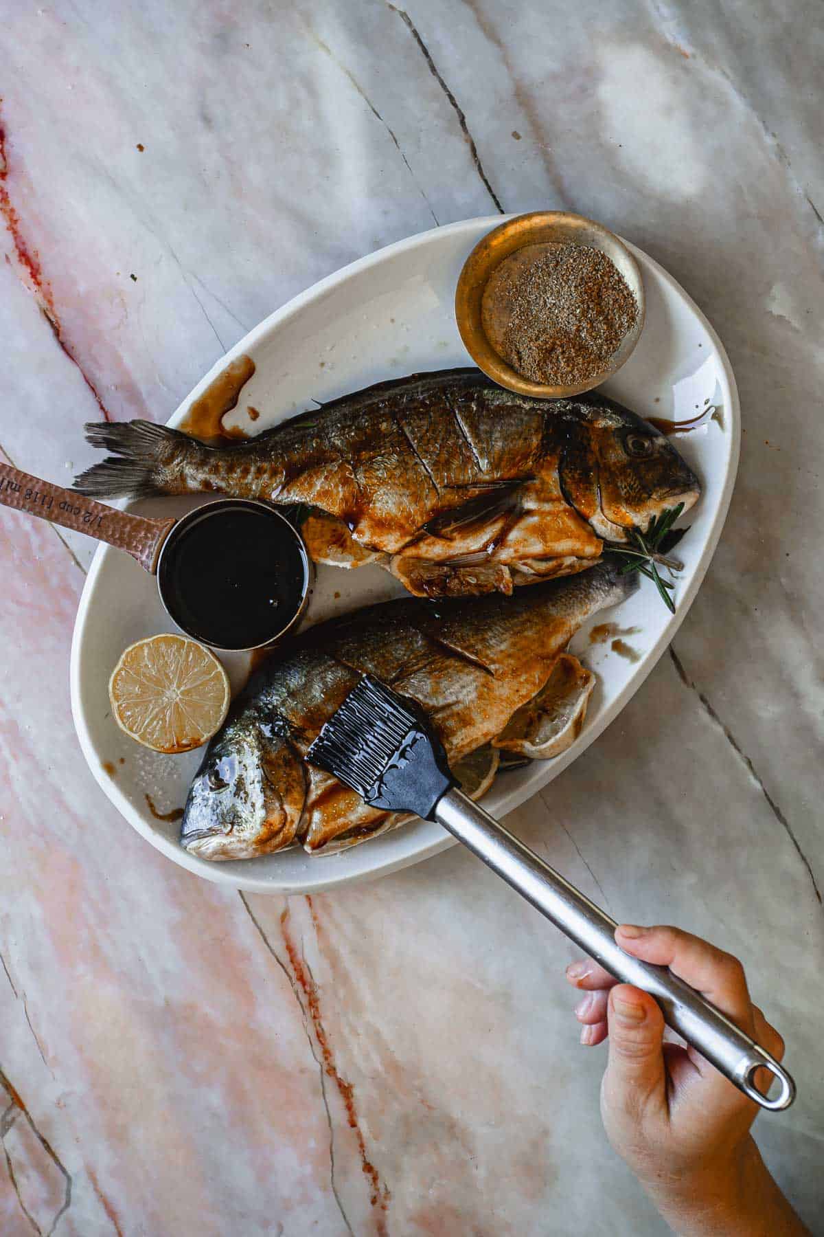 Raw whole fish covered in pomegranate sauce.