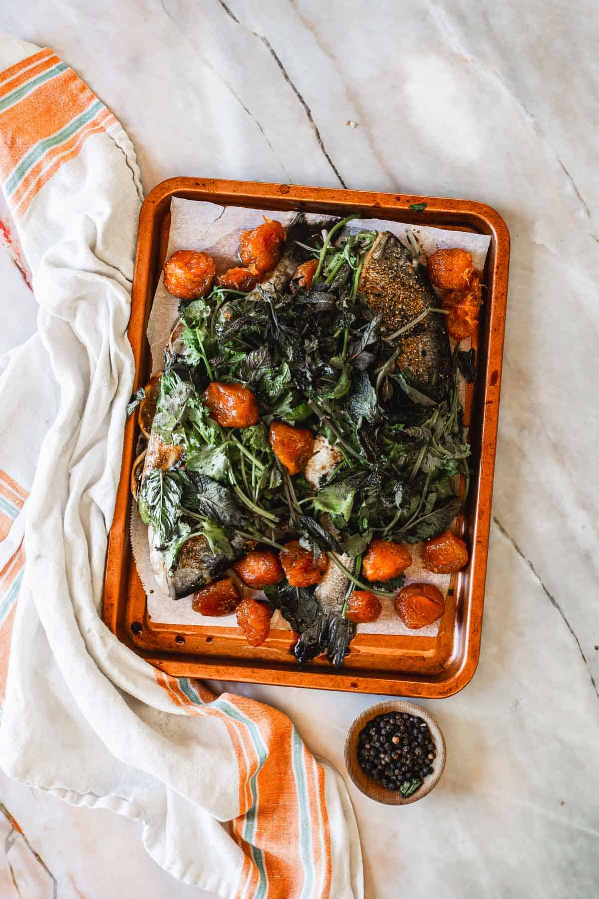 Two baked fish on a baking sheet.