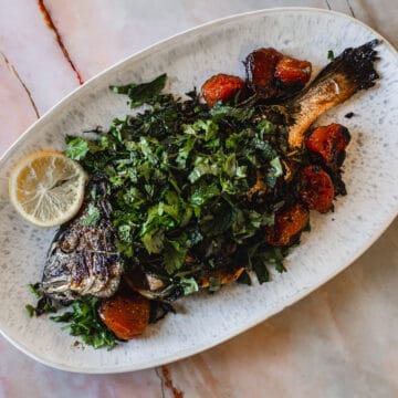 Plated whole fish on a white platter.