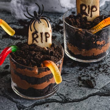Two halloween desserts in glasses with a rip in the middle.