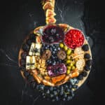 A platter of fruit and cheese with a scary face on it.