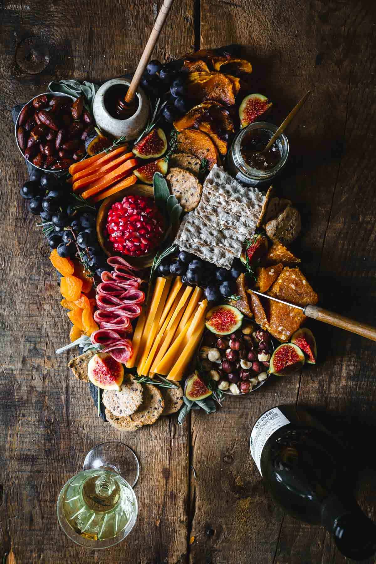 A platter of fruit, cheese and crackers on a wooden table.