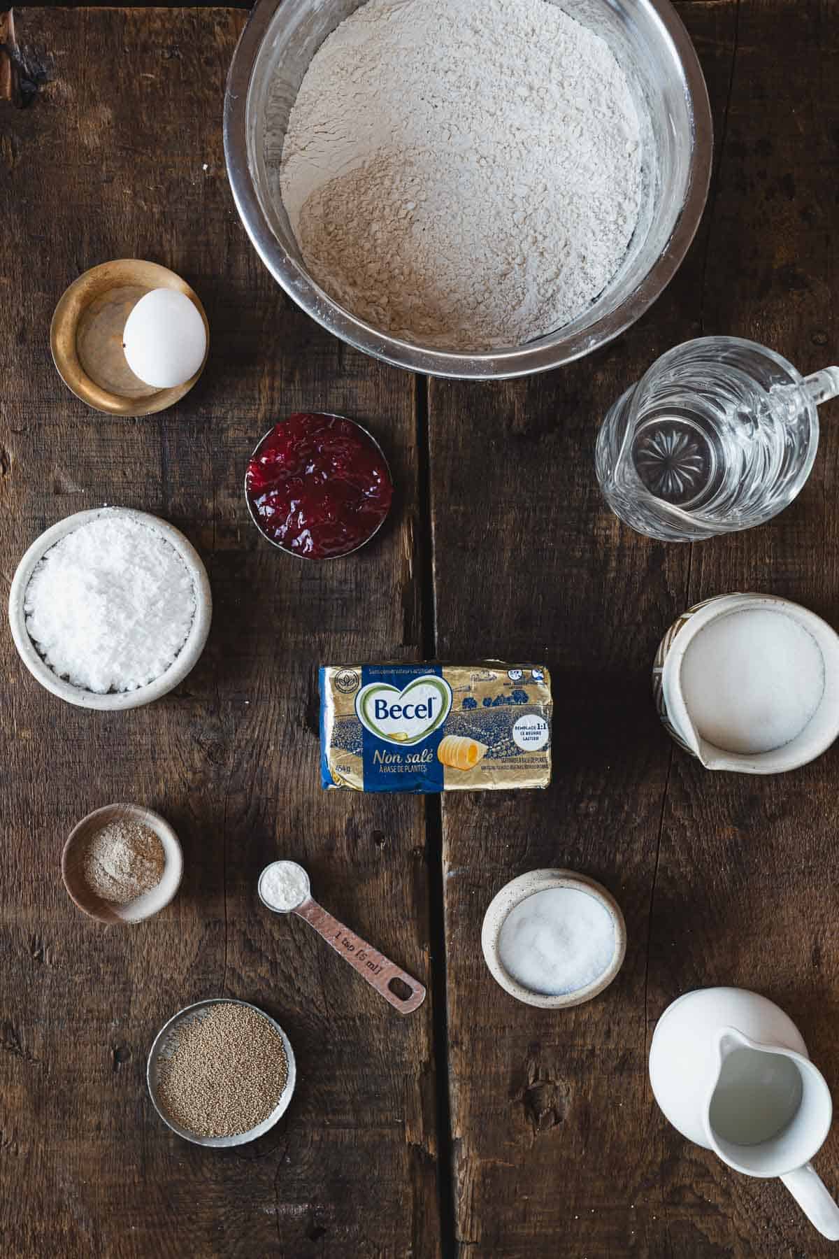 The ingredients for gluten free sufganiyot are laid out on a wooden table.
