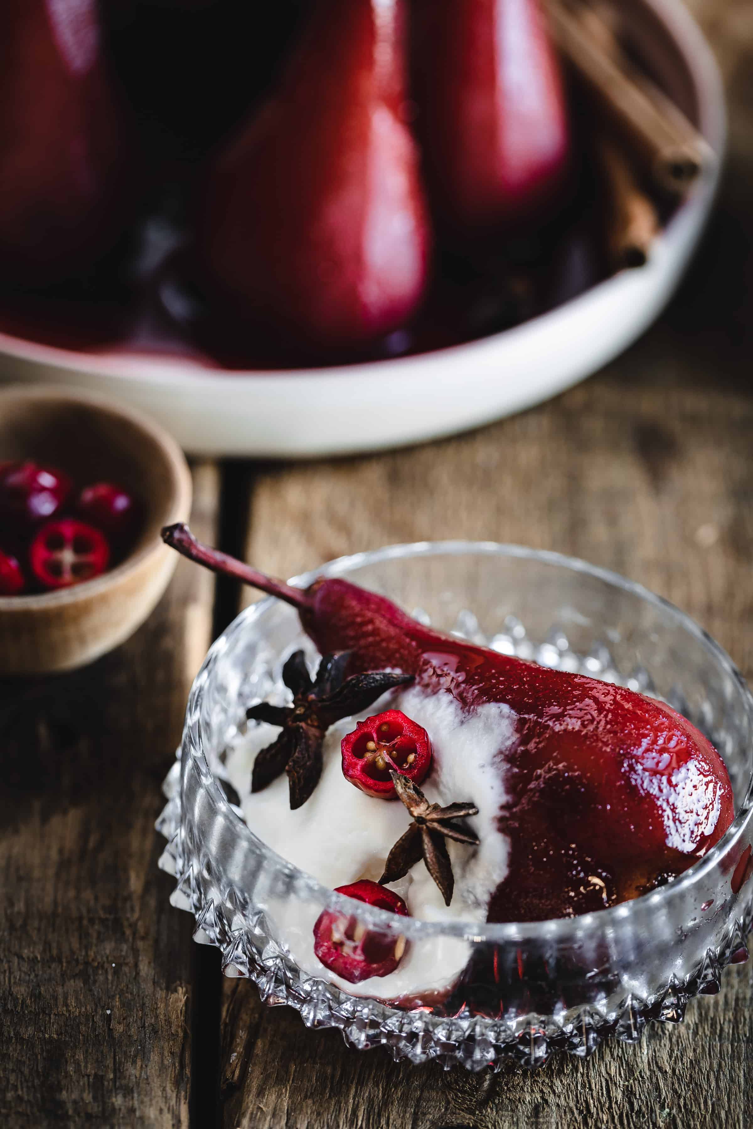 A bowl of pears with whipped cream and cinnamon.