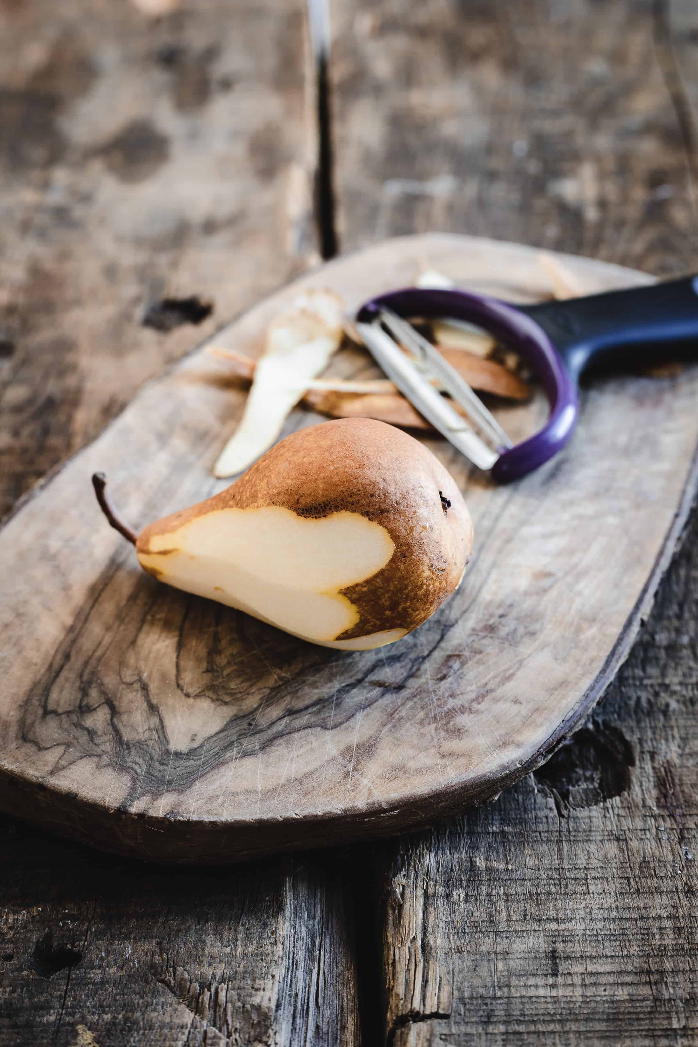 A sliced pear on a wooden cutting board.