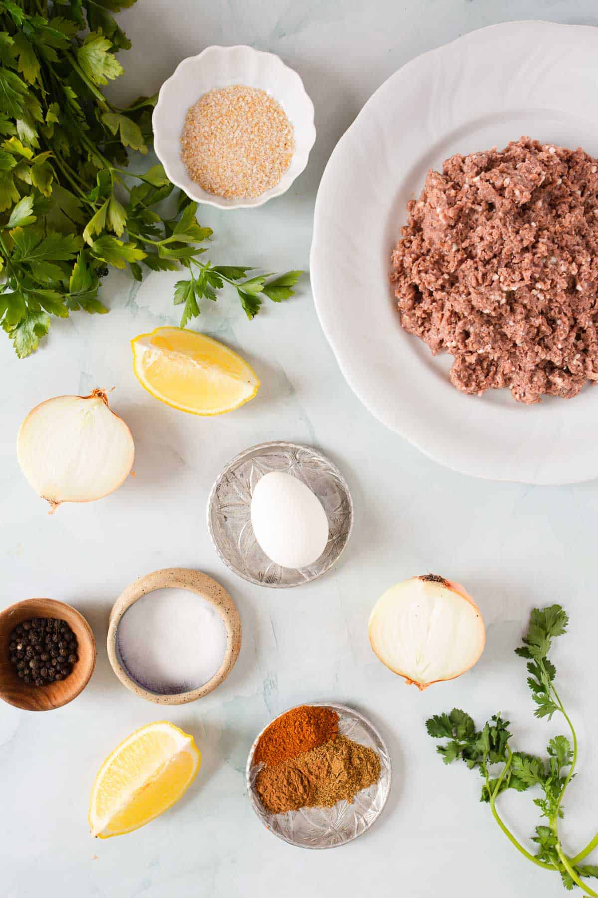 The ingredients for kofta kebabs are laid out on a table.